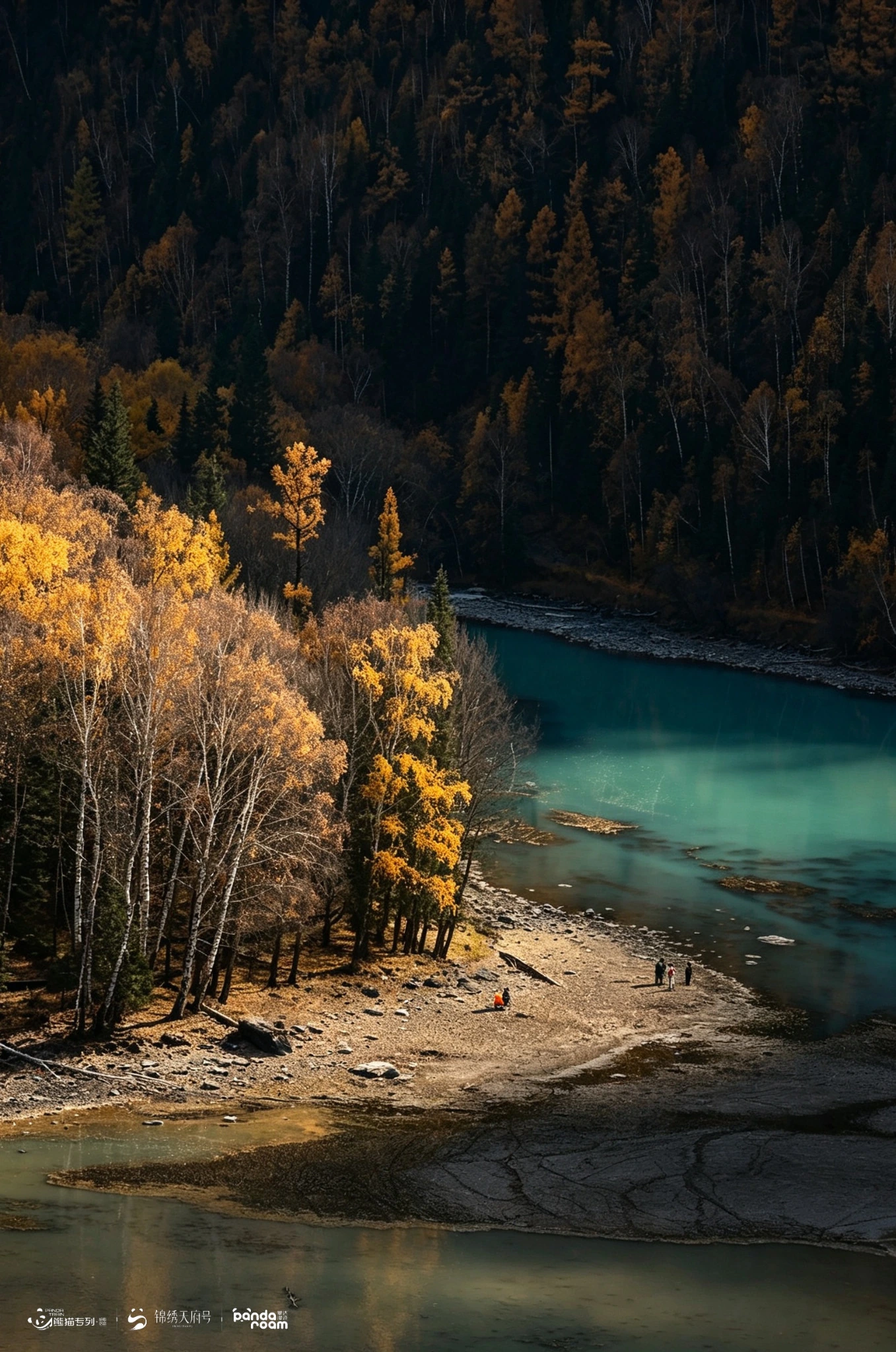 River bend beside a stony bank with autumn trees and distant visitors