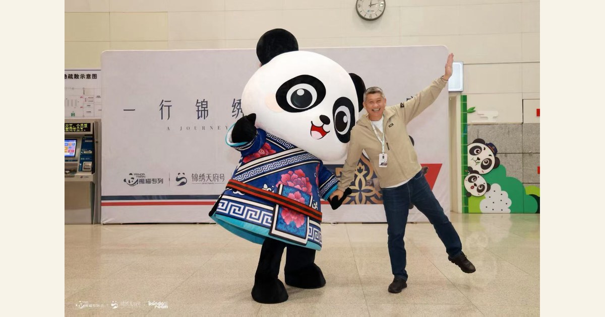 Guests pose with a panda welcome character in front of a Jinxiu Tianfu backdrop